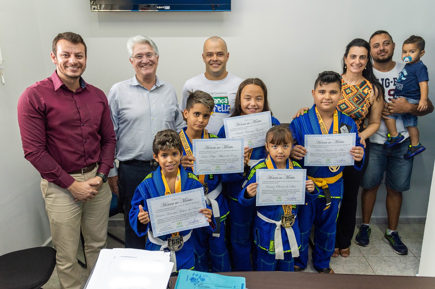 Alunos medalhistas do Criança Feliz, junto ao instrutor Danilo Pando, ao prefeito Bica, ao Secretário de Desenvolvimento Social, Alison Paulo da Silva e à Coordenadora do Serviço Criança Feliz, Telma Moreto. Foto: Luís Fernando da Silva / Prefeitura Municipal de Urupês.