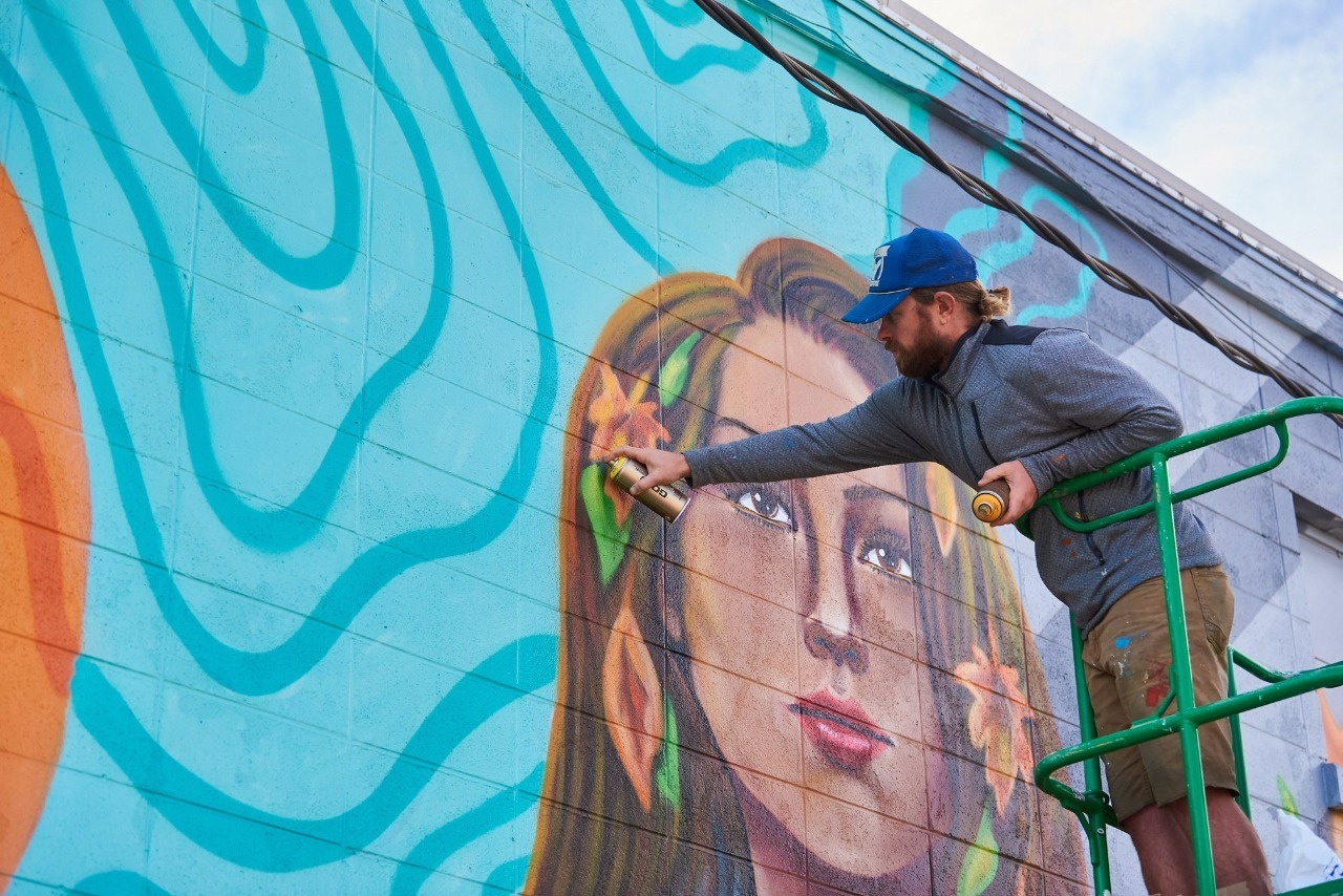 Artista plástico pintando mural. Foto: divulgação.