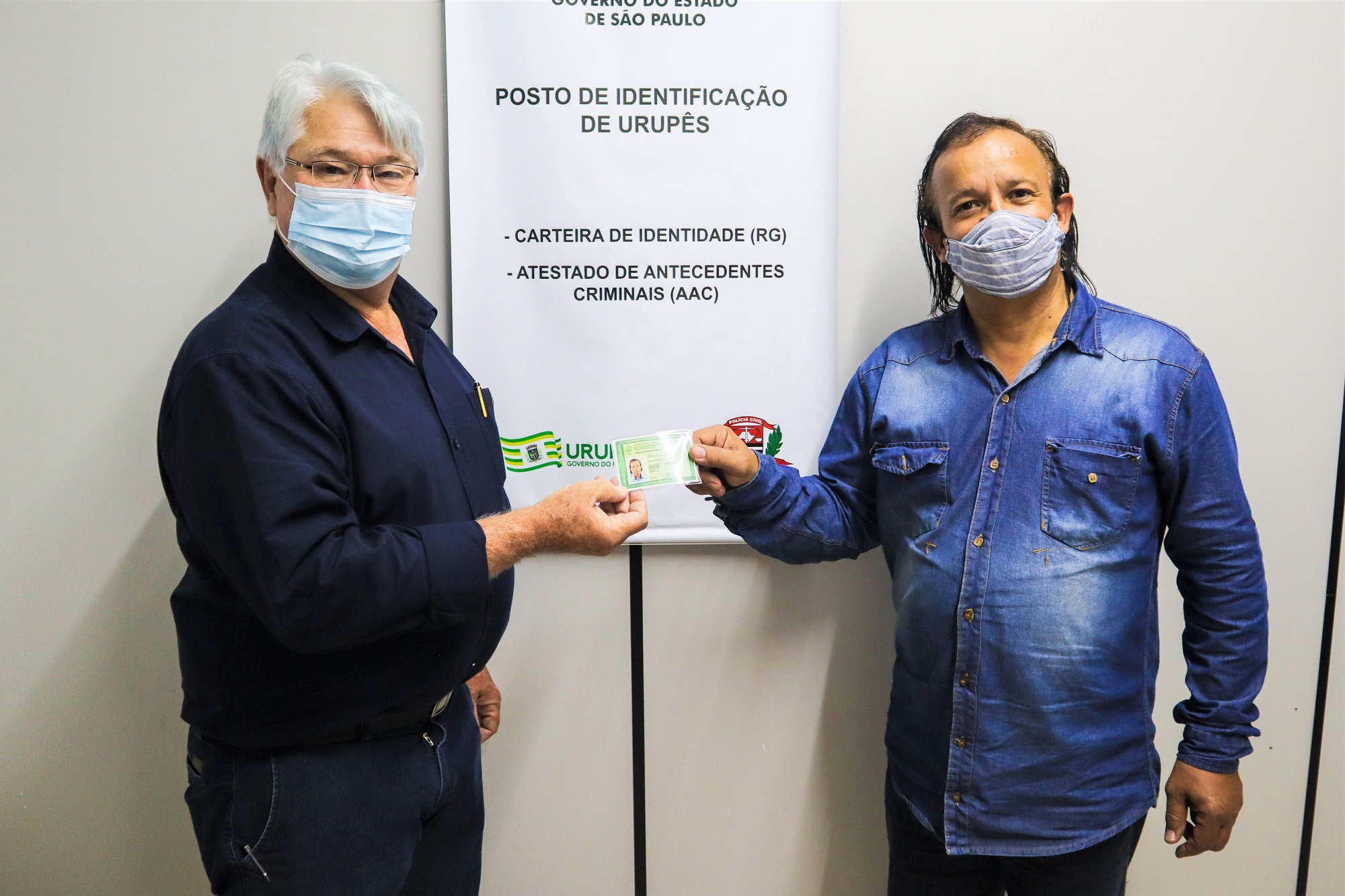 Prefeito Bica entrega documento de identidade para Marcos Menezes Salles, um dos munícipes beneficiados com o mutirão. Foto: Luís Fernando da Silva / Prefeitura Municipal de Urupês.