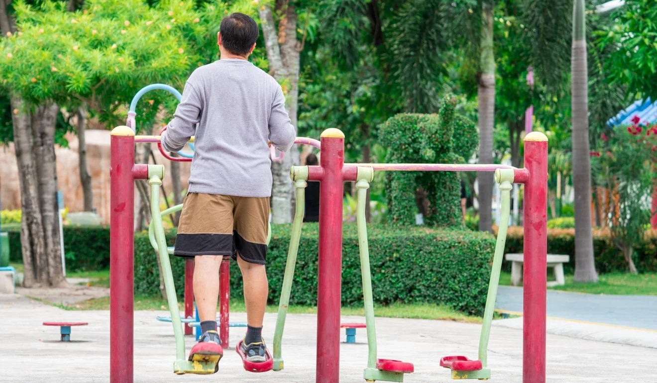 Idoso utiliza máquinas de alongamento em academia ao ar livre. Foto: Alamy.