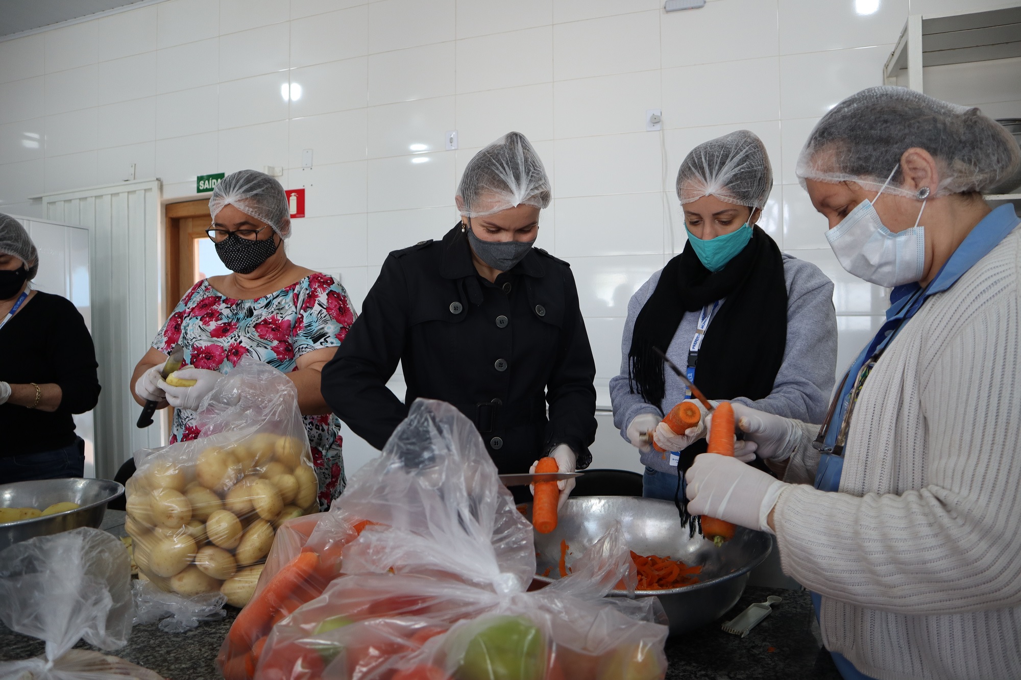 Funcionários da Secretaria de Desenvolvimento Social preparam alimentos para entrega nesta sexta-feira (30). Foto: Luís Fernando da Silva / Prefeitura Municipal de Urupês.