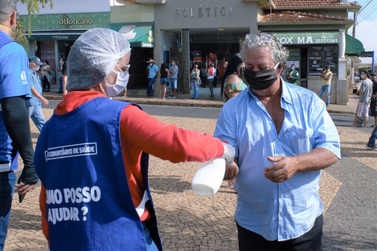 Moradores são orientados a manterem distância na fila de espera, seguindo as demarcações, e sobre formas de evitar a Covid-19. Foto: Divulgação.